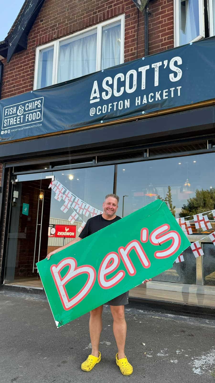 Person holding Ben's sign outside Ascotts Fish & Chips in Cofton Hackett.